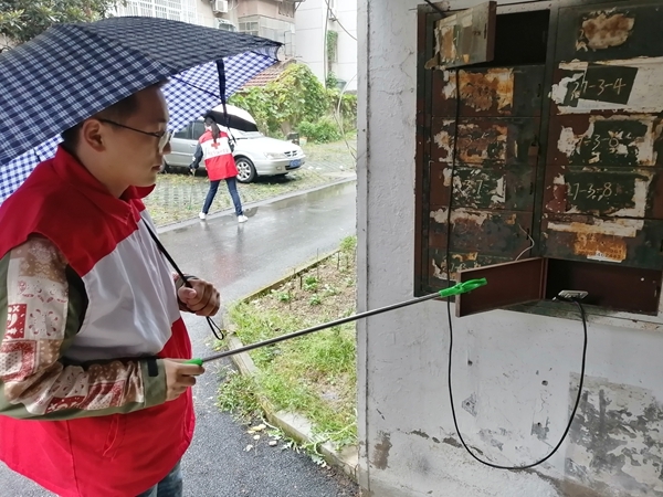 淮南市红十字会冒雨帮助共建社区清理环境卫生5